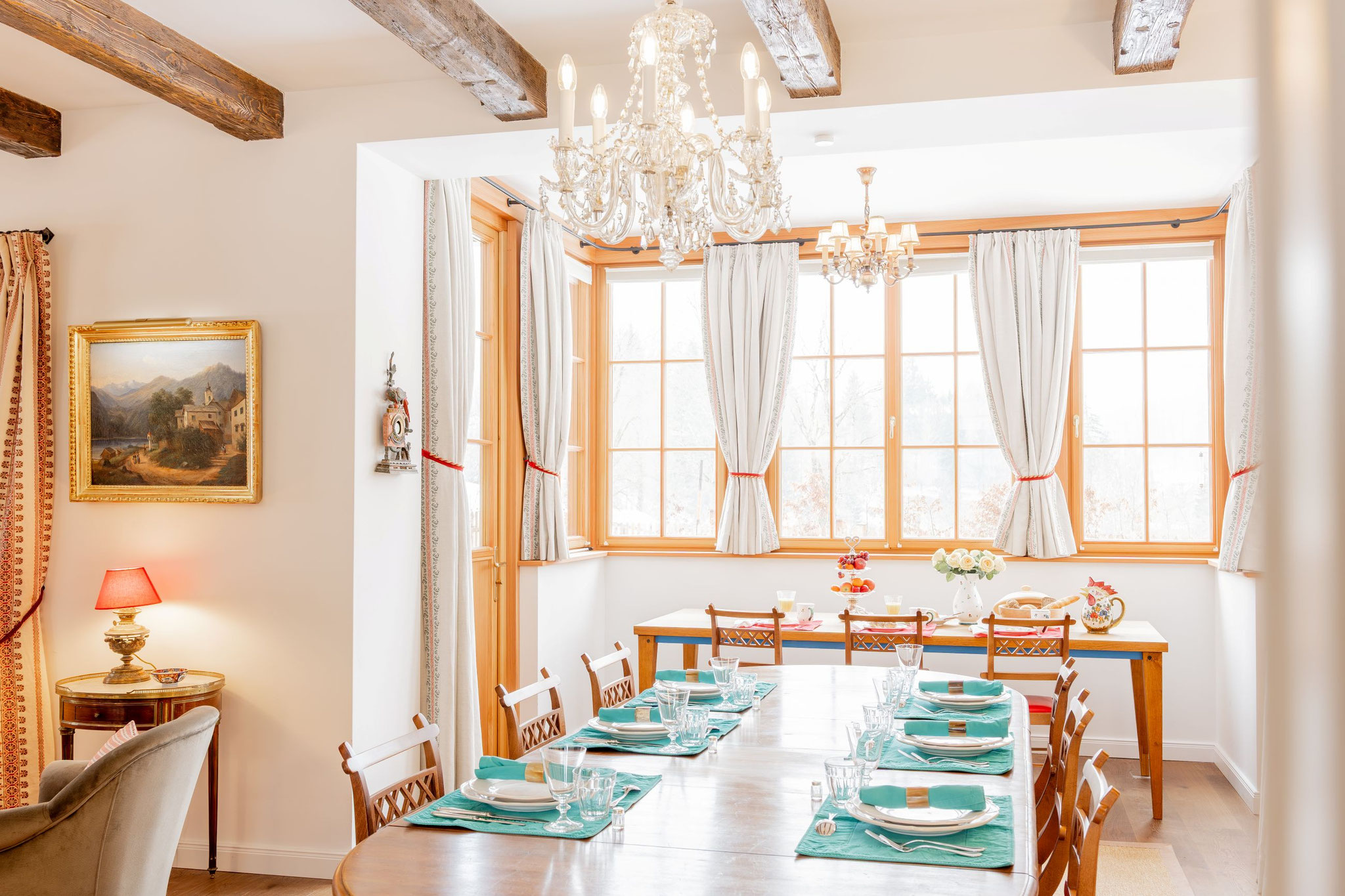 Großer Esstisch mit Kristalllustern und gedecktem Tisch für Abendessen