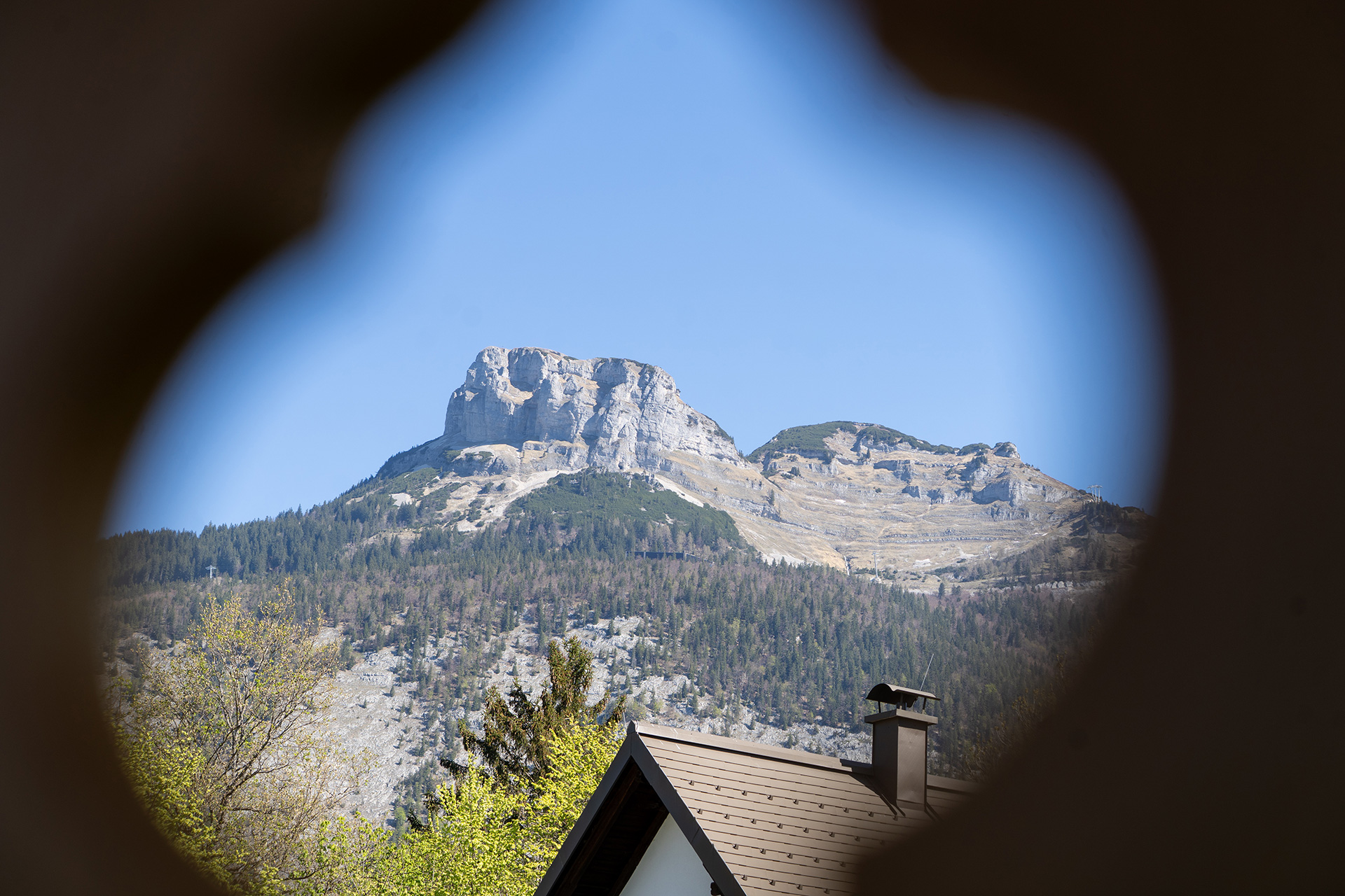 Blick auf den Loser durch einen Fensterladen mit Herzausschnitt im Gästehaus Eltz