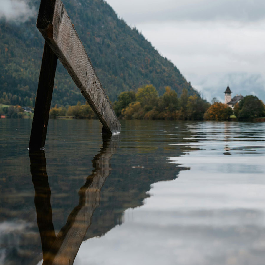 Klarer Bergsee mit Spiegelung der umliegenden Berge