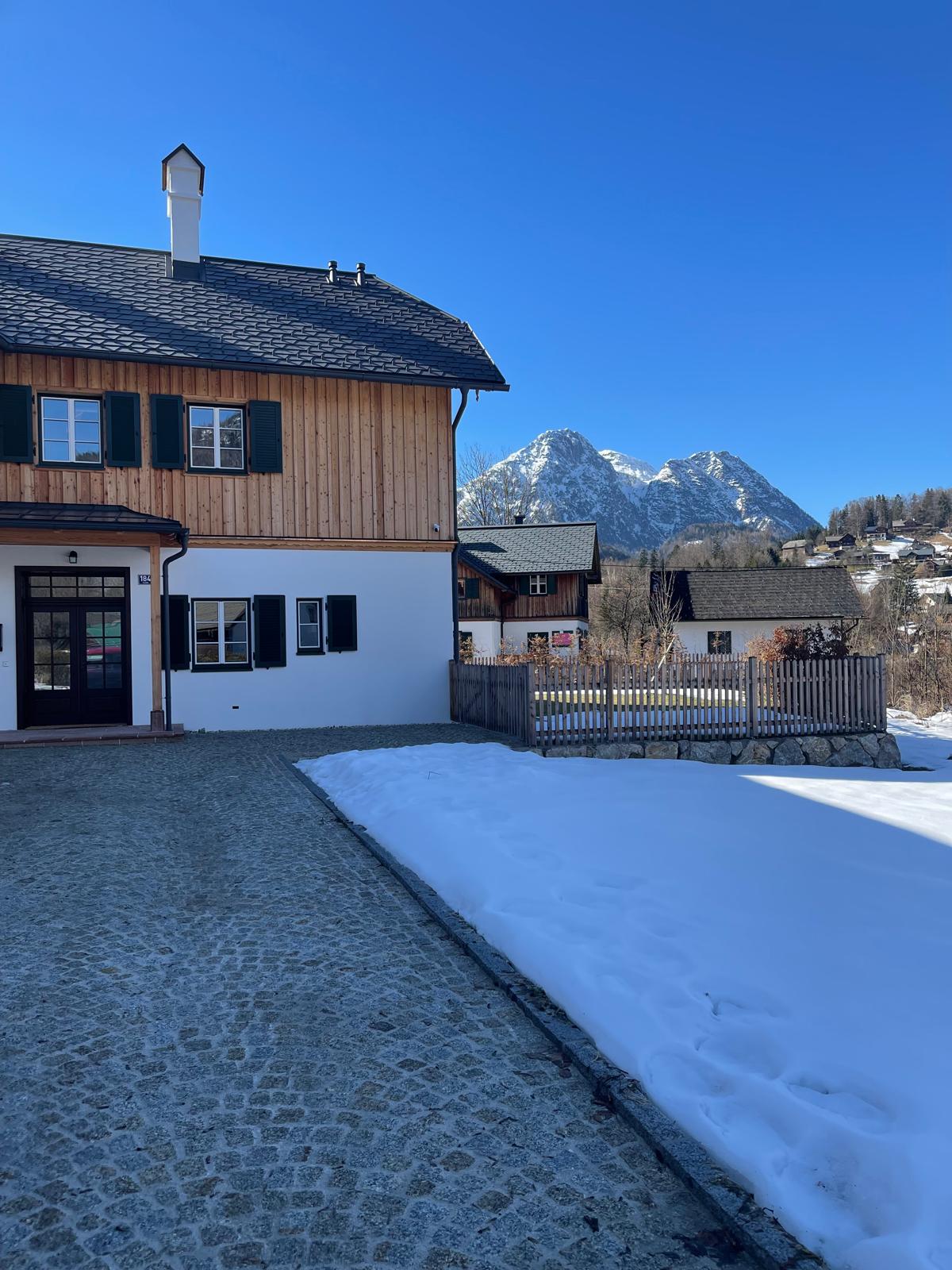 Das Gästehaus Eltz an einem klaren Wintertag, dahinter der verschneite Loser