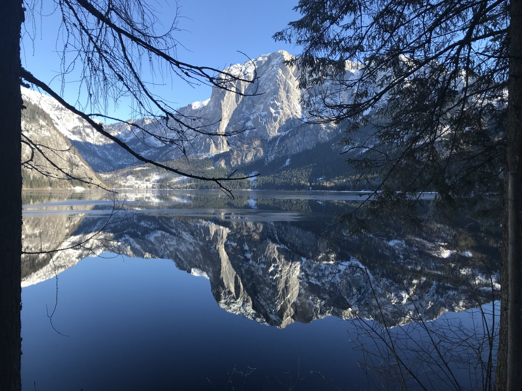 Winter in Altaussee – die verschneite Trisselwand spiegelt sich im spiegelglatten Altausseer See